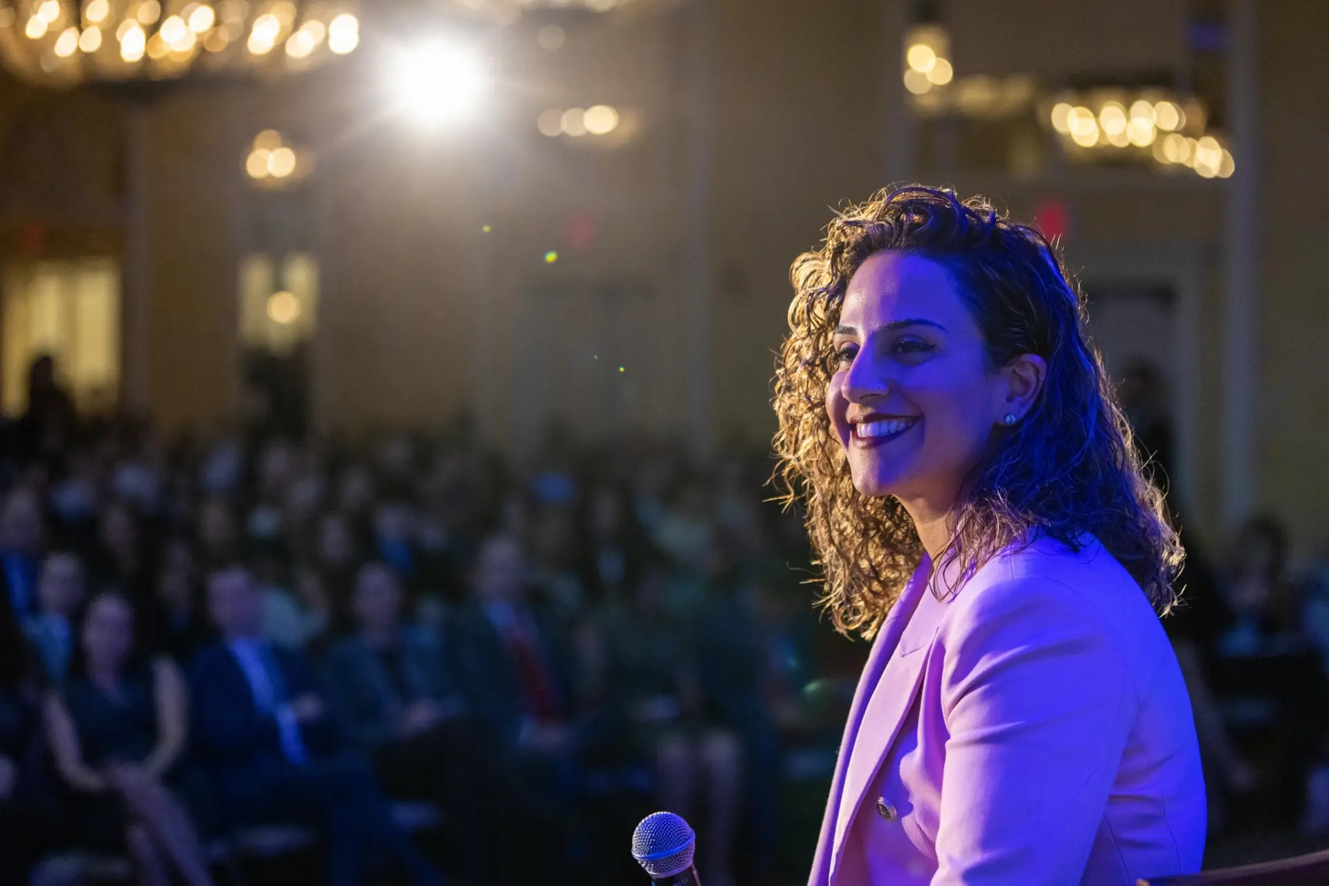 Farnoush Jafari speaking on stage at a Divine Retreats & Co. event