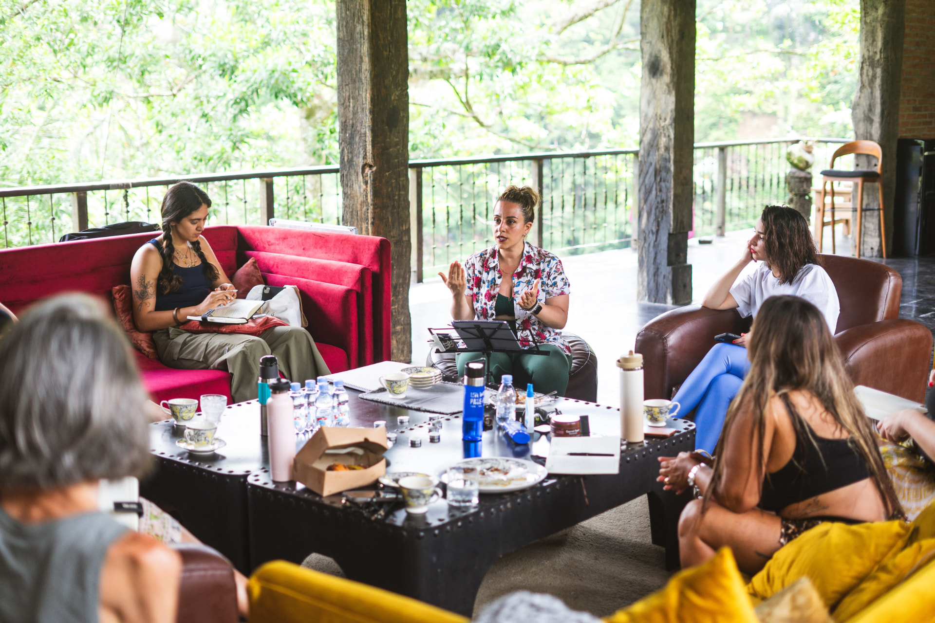 Small group in open conversation on a jungle terrace during a workshop.